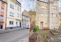 Ein Vierfamilienhaus mit stilvoller Fassade in einer Seitenstraße.